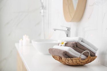 Basket with clean towels on counter in bathroom. Space for text