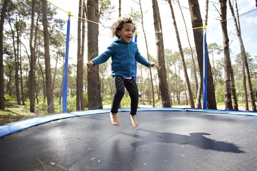 Mixed race girl jumping on trampoline