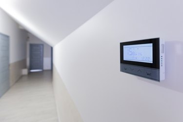 Control panel, air conditioning and heating system of the house, on a white wall, smart home