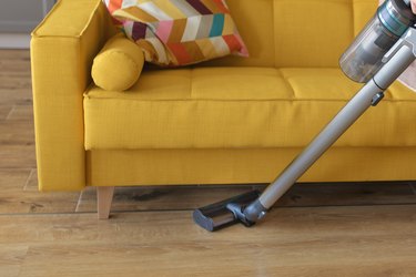 closeup of vacuum cleaner chores under sofa
