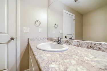 Top mount sink with stainless steel faucet on bathroom marble countertop