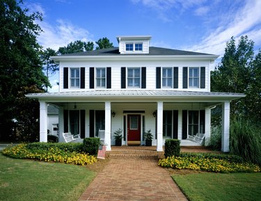 White wooden house, flowers blooming around front porch