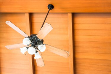 Low Angle View Of Electric Fan Hanging On Wooden Ceiling
