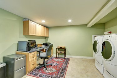 Basement room with laundry appliances and home office area.