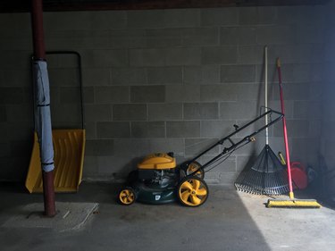 Газонокосилка и другие инструменты в гараже