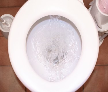 The white toilet bowl with stream water in bathroom