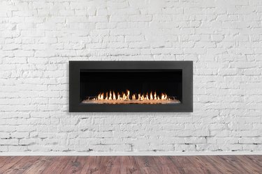 Gas Fireplace on white brick wall in bright empty living room interior of house