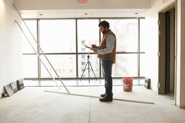 Foreman writing on clipboard at construction site