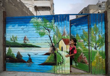 Landscape mural painted on wooden fence and gate.