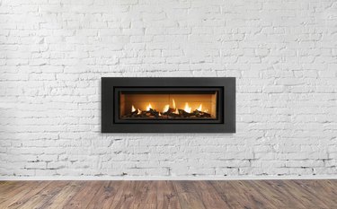 Gas Fireplace on white brick wall in bright empty living room interior of house