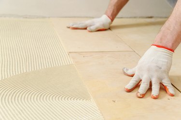 Laying plywood on a floor.