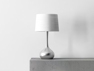 Stylish table lamp in white room.
