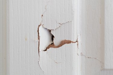 Close up of broken white wooden door