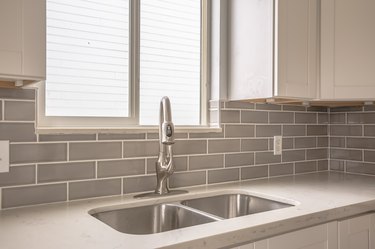 Undermount double bowl sink and faucet on the gleaming white kitchen countertop