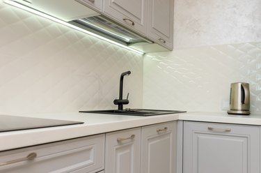 Beautiful interior of a classic kitchen in light gray and white colors with led lighting