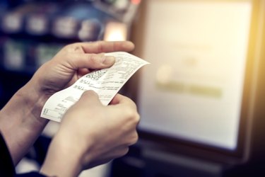 hands holding grocery store receipt