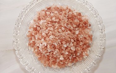 granules of natural Himalayan salt in a transparent glass plate