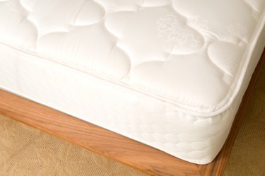 A white mattress on a hardwood floor