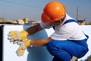Construction worker installing rigid foam insulation