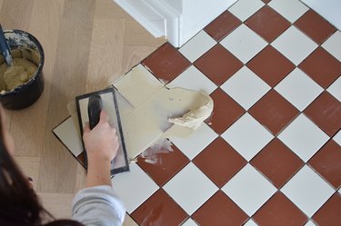 Grouting a red and white tiled hearth