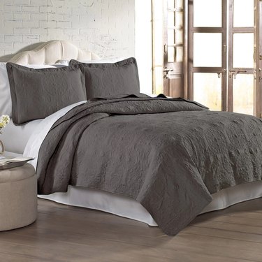 gray patterned quilt set on bed