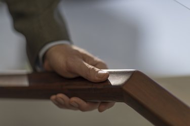 hand on wood handrail at the LightHouse for the Blind and Visually Impaired