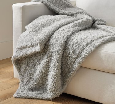 gray fuzzy blanket on couch
