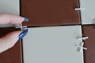 Placing tile spacers between red and white tiles