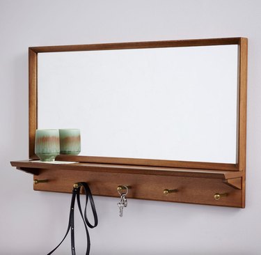 Pecan wood coat rack with large square mirror above the coat hooks