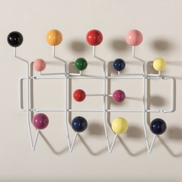 White hooks with colorful balls against a white wall