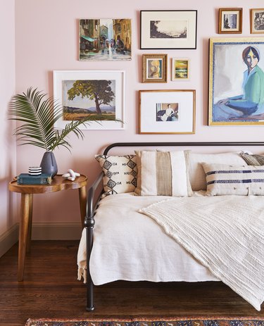 Pink-walled bedroom with an exotic feel and art gallery on the wall