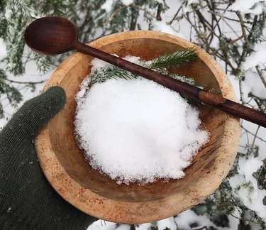 Fresh snow in a wooden bowl