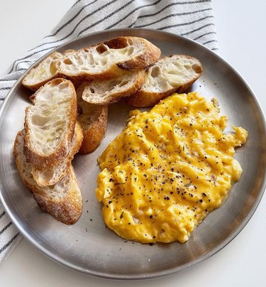 scrambled eggs and crispy toast on grey plate