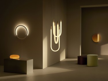 sculptural light fixtures, two coffee tables, and an illuminated glass doughnut