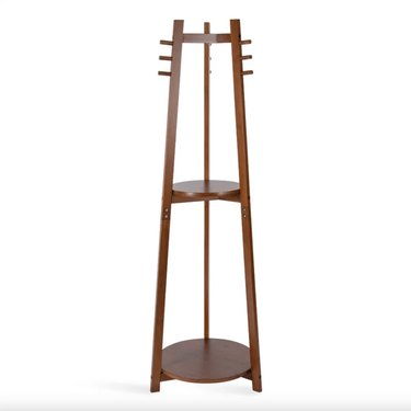 walnut freestanding coat rack with three posts coming into a conelike shape. Nine pegs for hanging coats and two center shelves