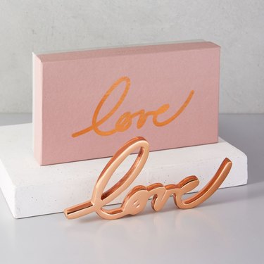 brass object that spells out love in calligraphy
