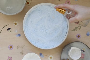 Spritzing shower steamers mixture with water in a small spray bottle