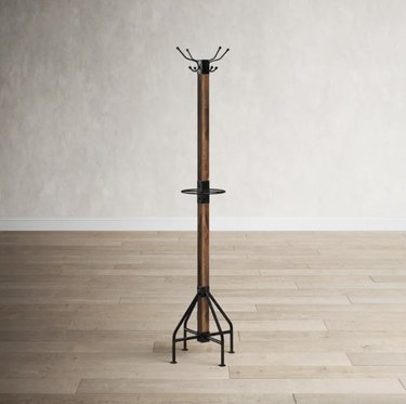Freestanding wood and iron coat rack with eight hooks and an umbrella stand