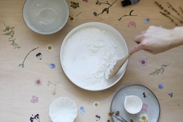 Stirring powdered ingredients for shower steamers in a large bowl