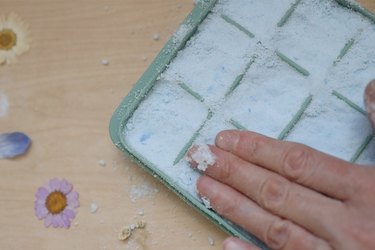 Pressing shower steamers mixture firmly into mold with hand