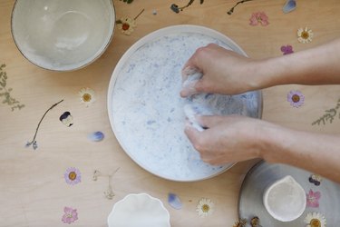 Mixing blue food coloring into the powdered mixture with hands