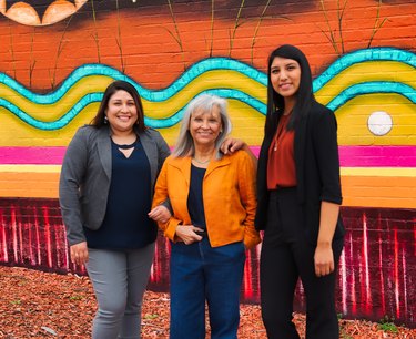 Margaret Roach Wheeler, Bethany McCord, and Taloa Underwood in front of a colorful mural.