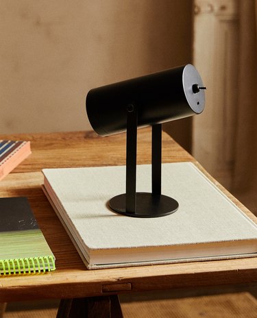 black desk lamp on top of a book
