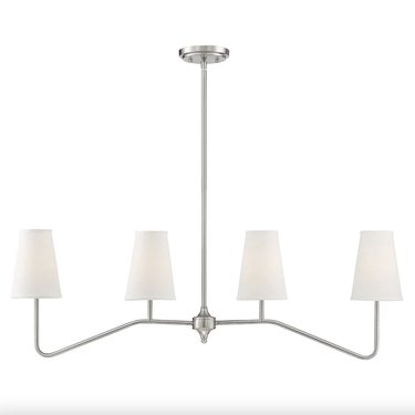 4-light silver linear chandelier with white shades against a white backdrop
