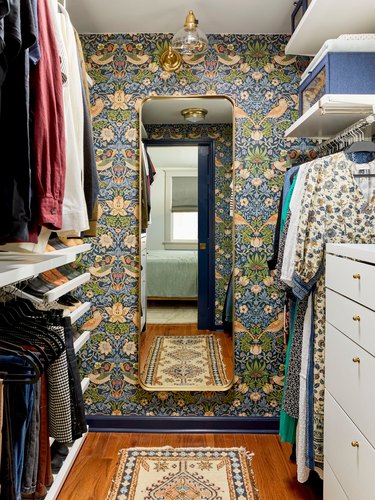 Walk-in closet designed by Sara Ligorria-Tramp with ornate floral and bird motif wallpaper.