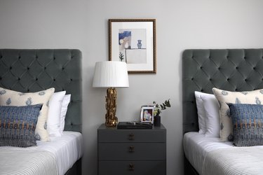 bedroom space with two tufted headboards and a nightstand with a lamp