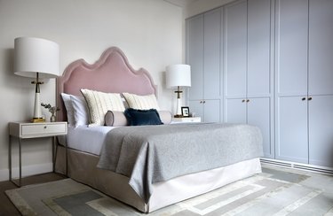main bedroom space with pink headboard and blue doors on the side