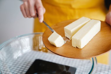 Two sticks of butter on a wooden plate