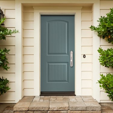A blue-gray fiberglass door on a white house
