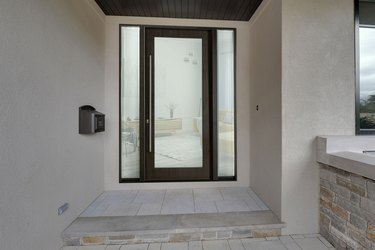 A modern glass front door on a covered entryway